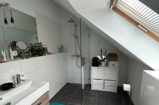 Badezimmer mit Dusche und Waschbecken mit Dachschräge mit Dachfenster